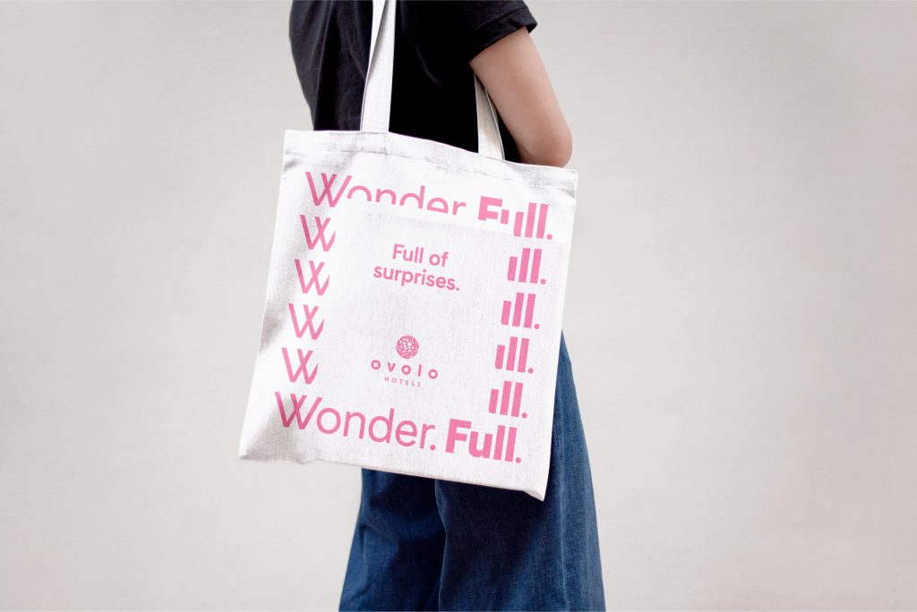 Ovolo Wonder.Full. Brand Refresh/Campaign – Tote Bag With Typographic Brand Pattern Framing Statement "Full Of Surprises"